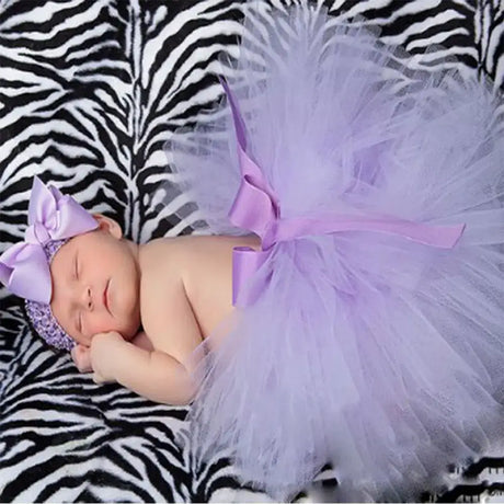 Infant girl in lavender tutu skirt and matching headband on a zebra print background, ideal for newborn photography.