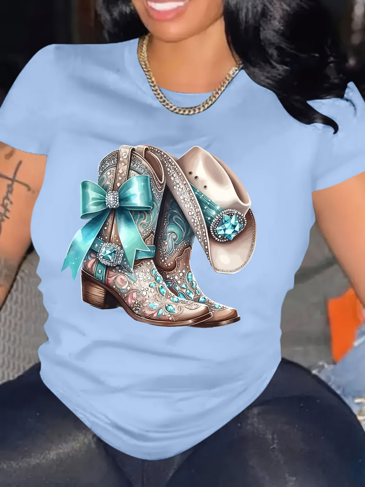 Elegant blue t-shirt featuring embellished cowboy boots design with turquoise accents, perfect for casual outfits.