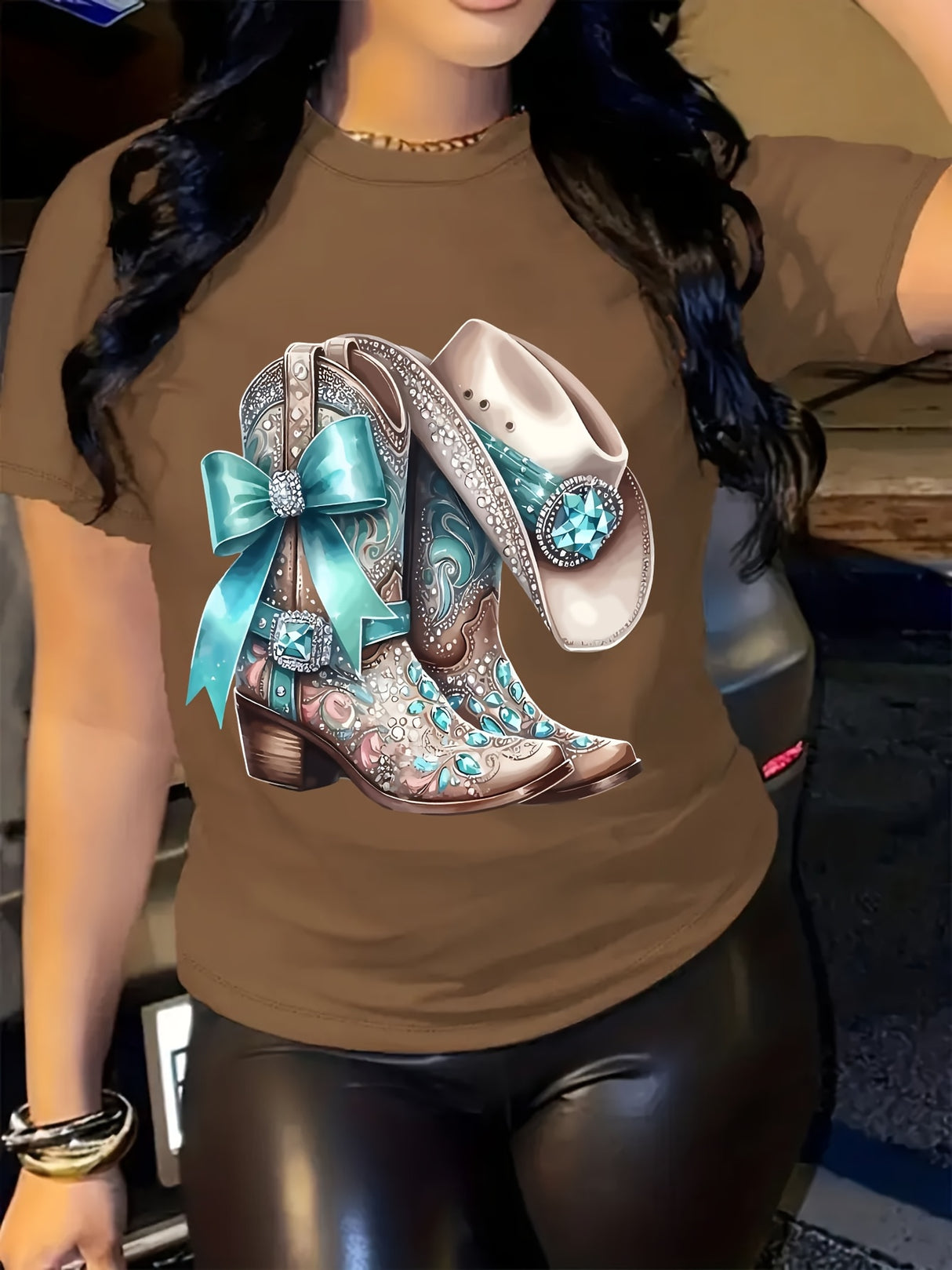 Brown T-shirt featuring stylish cowboy boots and a hat graphic with a blue bow, perfect for casual wear.