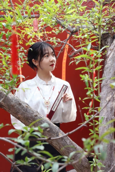Woman wearing a traditional Hanfu outfit among greenery, showcasing cultural attire in a vibrant, natural setting.